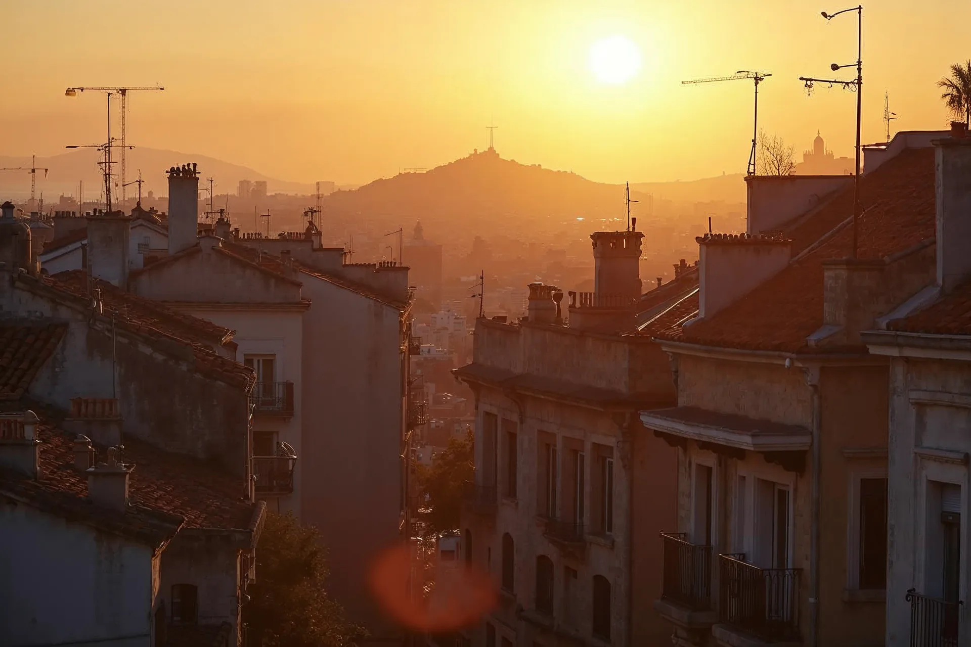 Barcelona tetői arany esti fényben, mediterrán építészettel.
